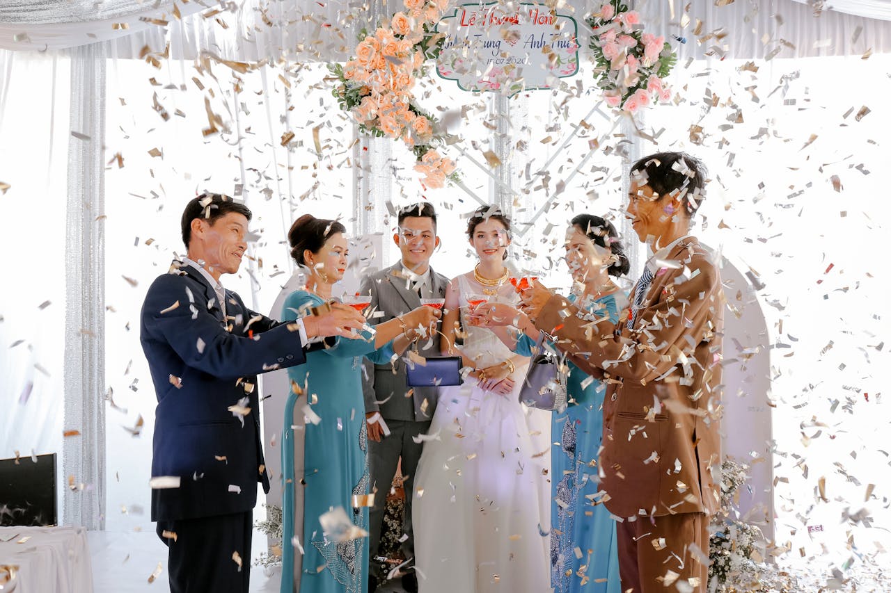 Happy newlyweds with guests on wedding celebration